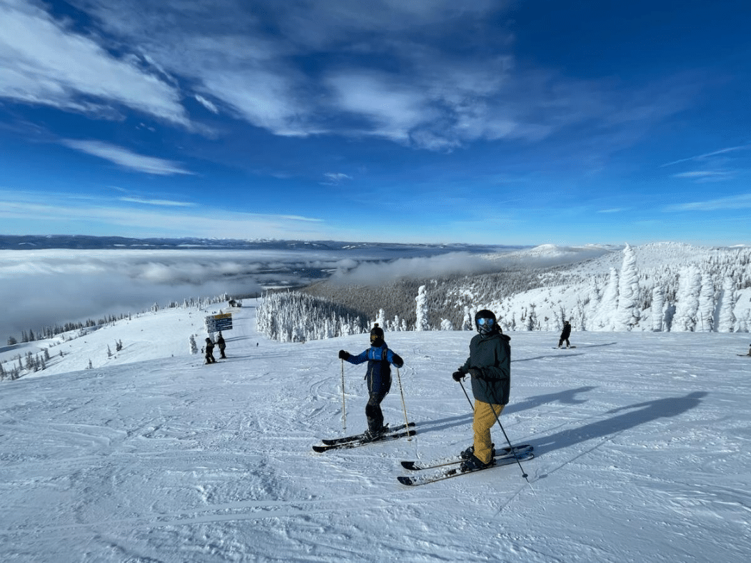 two people posing for a photo before skiing at whitefish mountain resort
