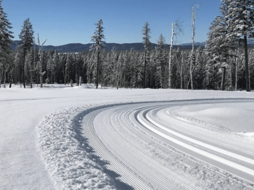 a groomed ski trail against the mountains